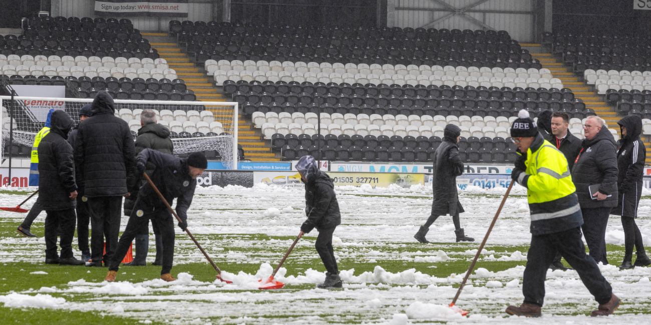 Volunteers and staff clear up the pitch at The SMiSA Stadium